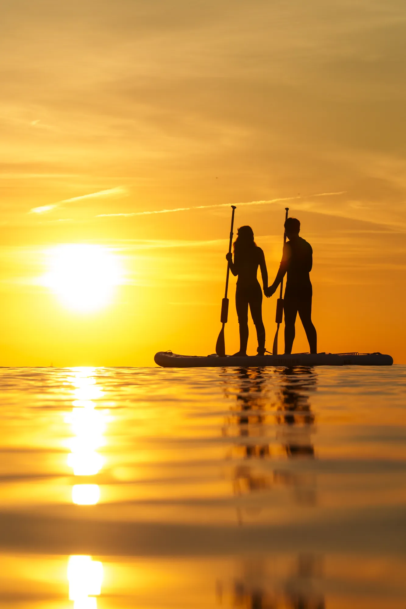 Sunset paddle board tour Barcelona — couple at golden hour on the Mediterranean