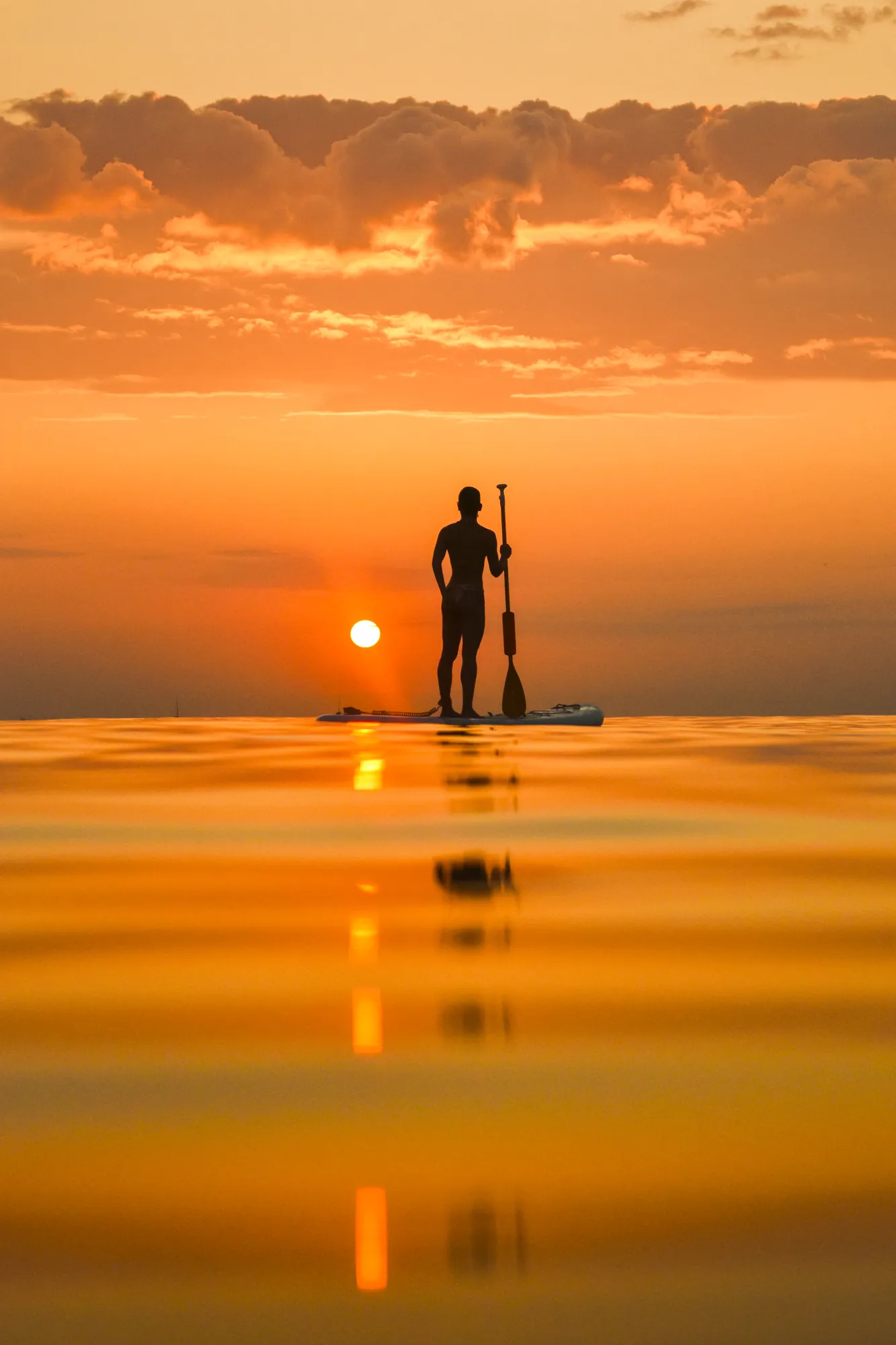 Sunrise paddle board tour Barcelona — paddler at dawn on Barceloneta Beach